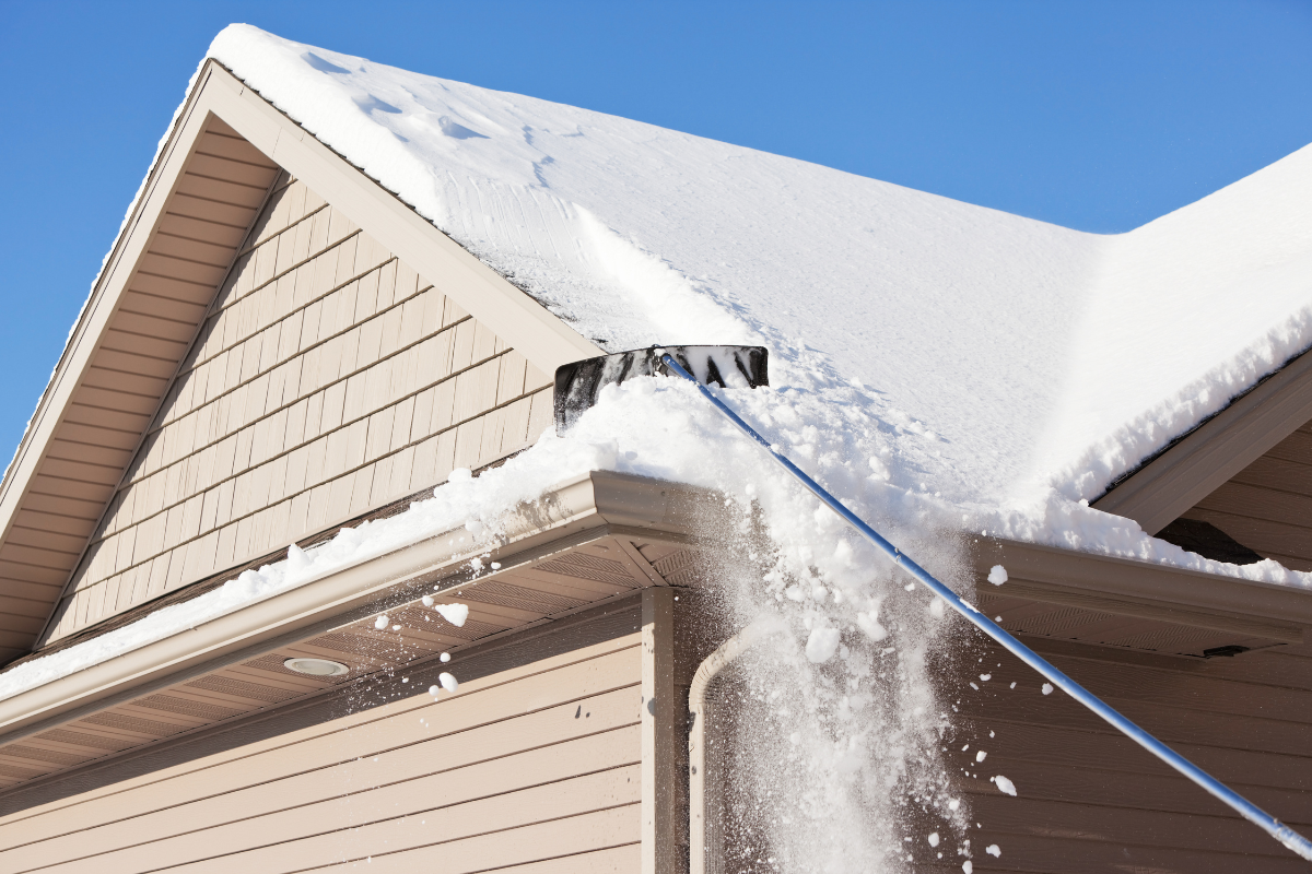 man using roof rake from ground