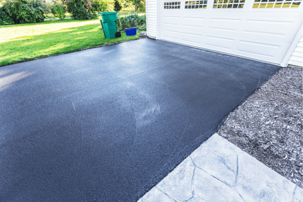 freshly sealed asphalt driveway suburban home